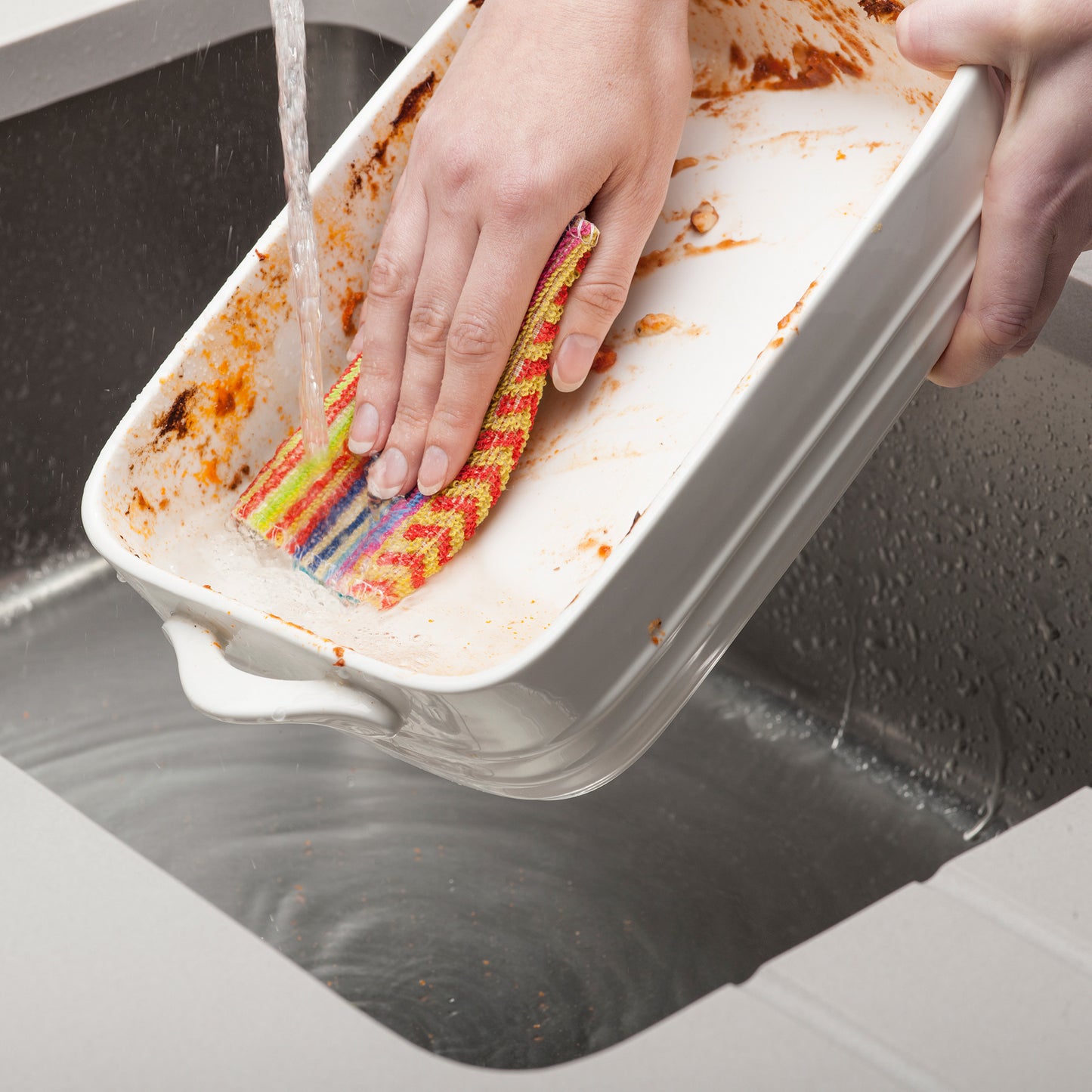 Person cleaning large caserole dish with a Large Kilo Scrubby non scratch Large eco-friendly